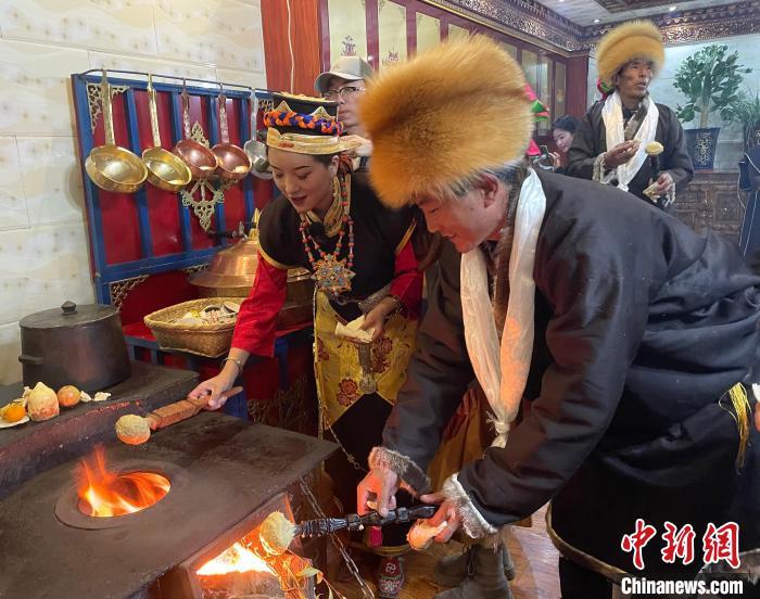 圖為人們?cè)诨鹕峡竟?jié)日美食“結(jié)達(dá)”?！∪轿木?攝