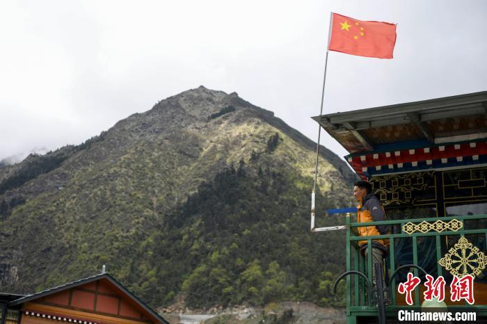 村民站在樓房上觀望?！钊A峰 攝