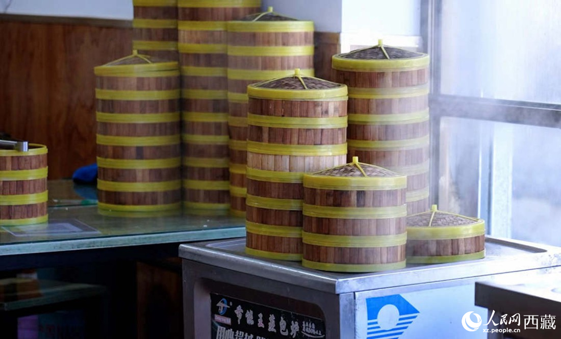 電蒸箱上擺滿了多屜熱氣騰騰的包子。人民網 次仁羅布攝