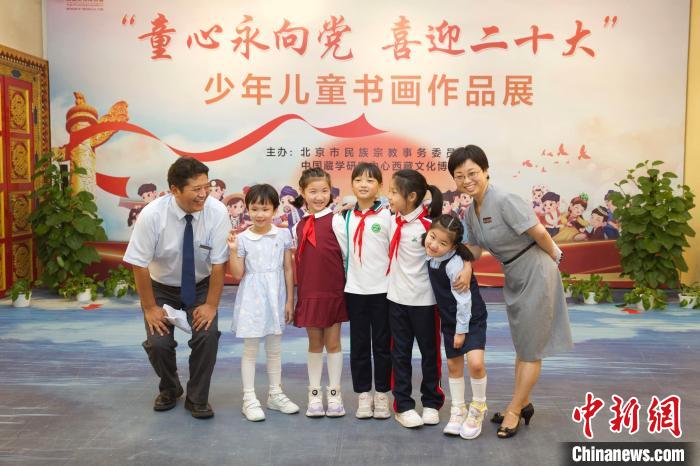 圖為與會嘉賓與入選畫作的“小作者”們在展覽上合影?！≈袊貙W(xué)研究中心供圖