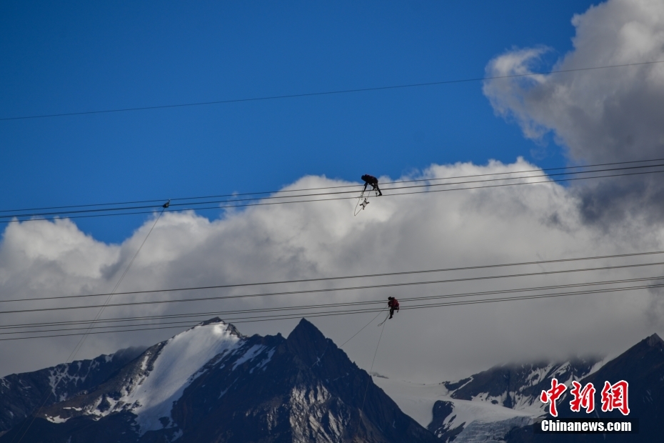 資料圖為2020年6月23日，西藏阿里聯(lián)網(wǎng)工程施工人員在日喀則希夏邦馬雪山附近進(jìn)行走線作業(yè)，安裝絕緣設(shè)備。 <a target='_blank' href='/'><p  align=
