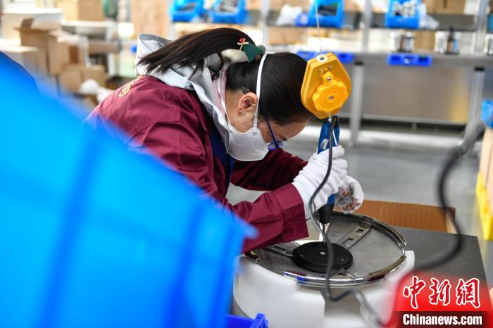 圖為工人正在組裝炊具?！∝暩聛硭?攝