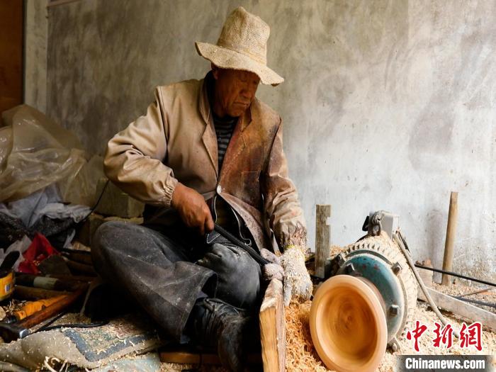 圖為手工藝人正在制作木碗?！?鄧海平 攝