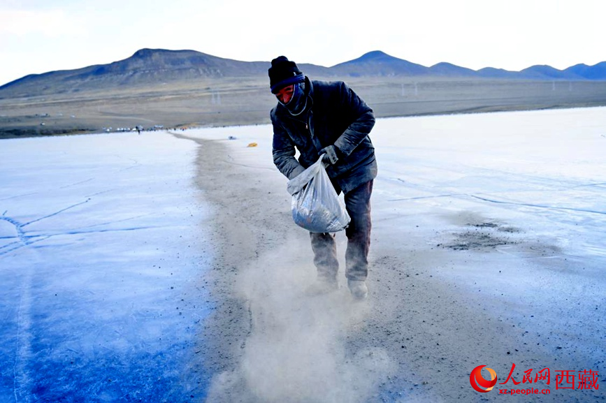 牧民在冰面上撒灰鋪成通道。人民網(wǎng) 李海霞攝