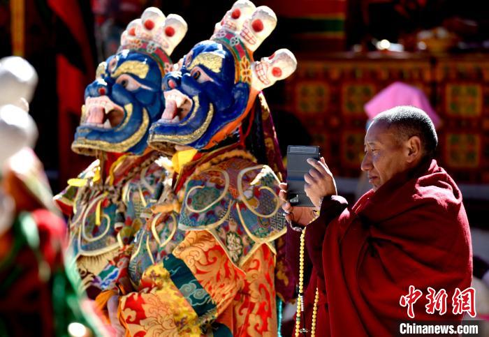 2月19日，正在拍攝跳神活動(dòng)的僧人?！±盍?攝