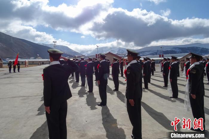 雪山下，退役士兵向軍旗敬軍禮?！±顚W(xué)文 攝