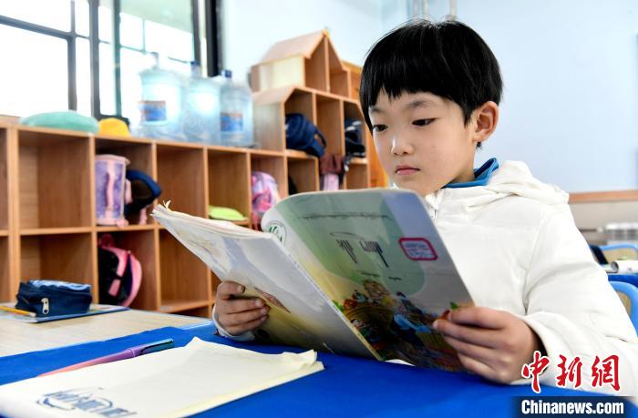 3月14日，西藏拉薩市第一小學(xué)一年級(jí)六班學(xué)生丁增樂(lè)吉在閱讀藏語(yǔ)課本。　李林 攝