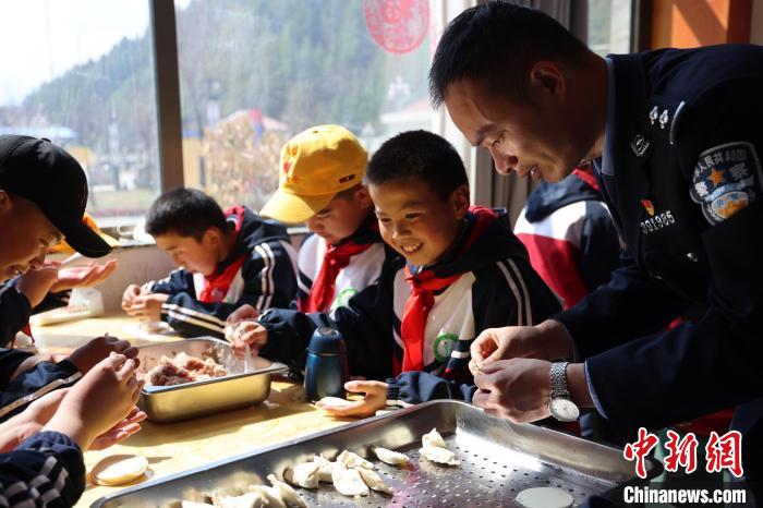 圖為亞東邊檢站民警與駐地小學(xué)生其樂融融包餃子。　胡利媛 攝