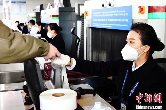 圖為機場工作人員為旅客辦理行李托運?！≈芎?攝