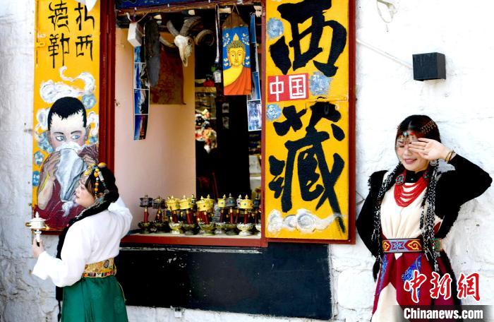 4月17日，游客身著藏式元素服裝在拉薩八廓街拍照留念?！±盍?攝
