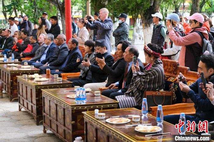 5月19日，中外嘉賓在羅布林卡和游客一起觀看藏戲?！〗w波 攝