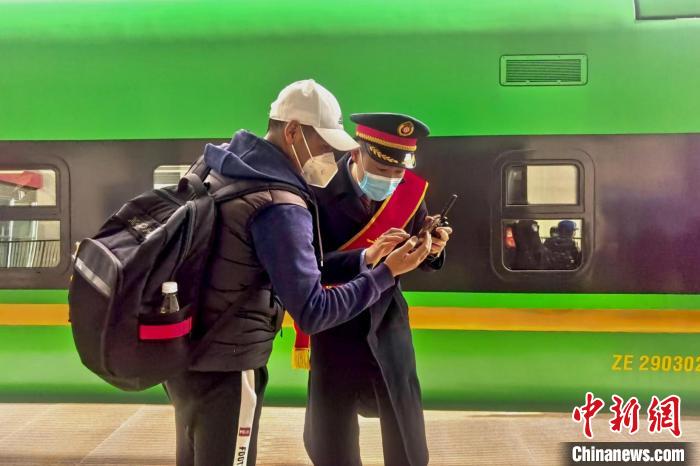 圖為日喀則火車站工作人員服務(wù)乘客?！《飞降?攝