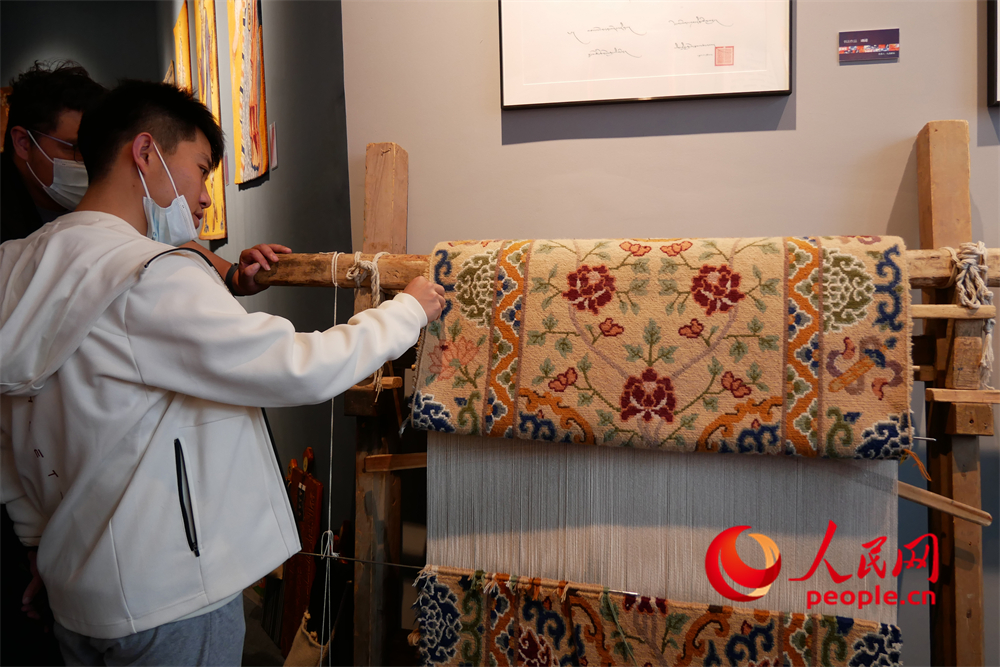 觀眾正在觀賞展出的藏毯。人民網(wǎng) 韋衍行攝