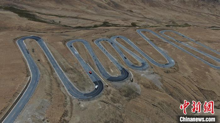 圖為騎手前往珠峰大本營途經(jīng)108道拐?！∮文恋厍蚬﹫D