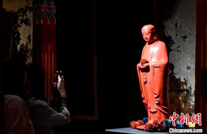 圖為觀眾正在欣賞展覽中的雕塑作品。