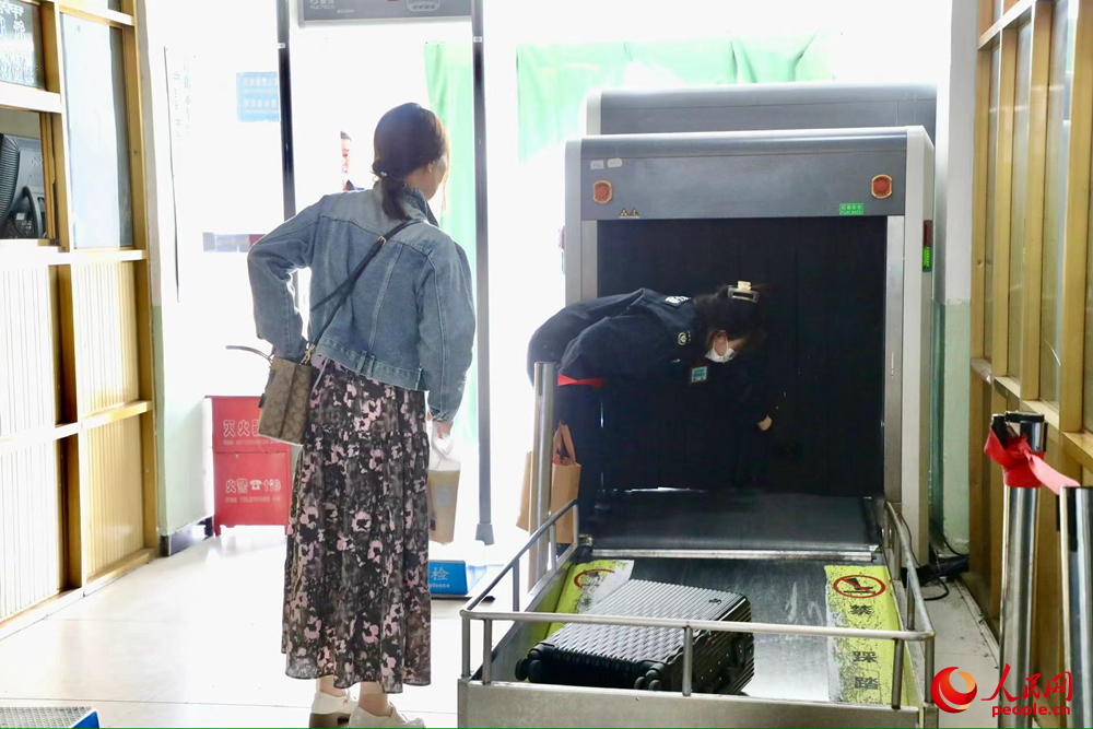 車(chē)站工作人員幫旅客提取行李。人民網(wǎng)記者 次仁羅布攝