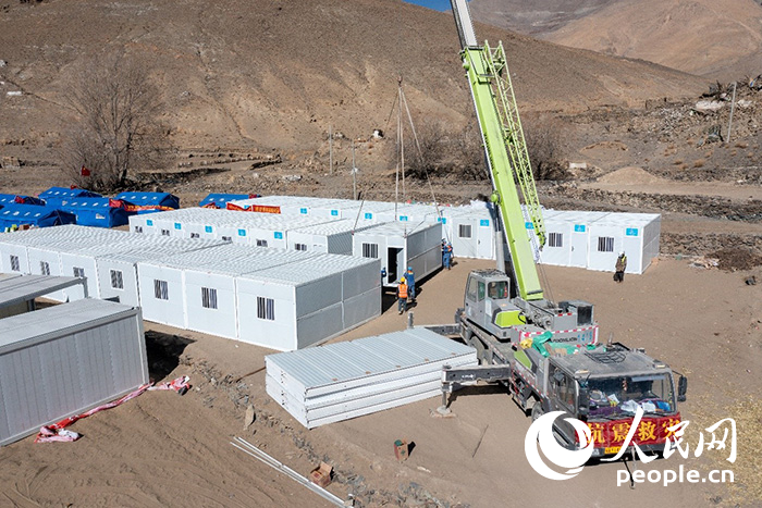 1月9日，在日喀則市定日縣長(zhǎng)所鄉(xiāng)古榮村安置點(diǎn)，救援人員和施工人員合力抓緊搭建移動(dòng)板房，確保受災(zāi)群眾溫暖過(guò)冬。人民網(wǎng)記者 翁奇羽攝