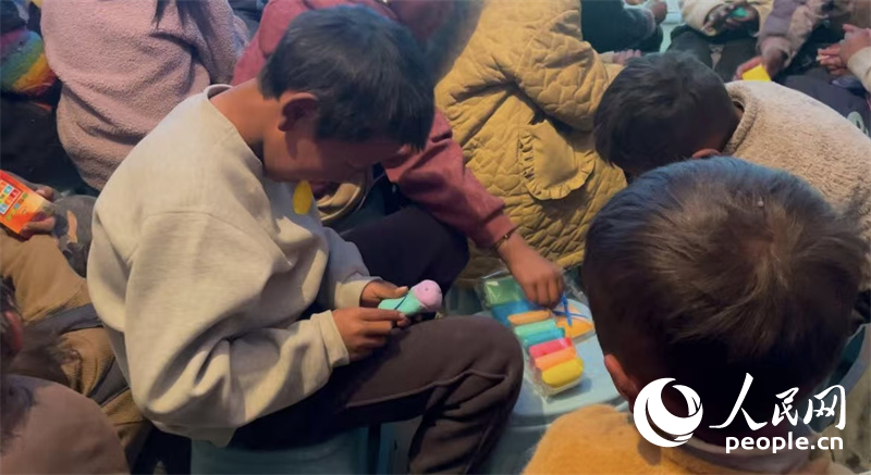 措果鄉(xiāng)塘仁村的孩子們正在用橡皮泥制作自己的情緒“小怪獸”。人民網(wǎng)記者 郝潔攝