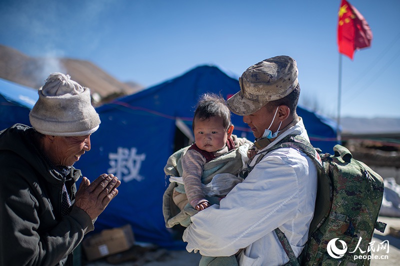 1月9日，在定日縣長(zhǎng)所鄉(xiāng)古榮村安置點(diǎn)，受災(zāi)群眾感謝西藏軍區(qū)陸軍某部隊(duì)衛(wèi)生員的醫(yī)療救治。人民網(wǎng)記者 翁奇羽攝